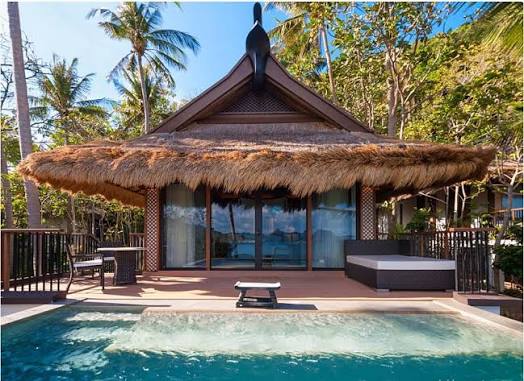 Tropical open-air villa with thatched roof, timber deck and natural wood construction